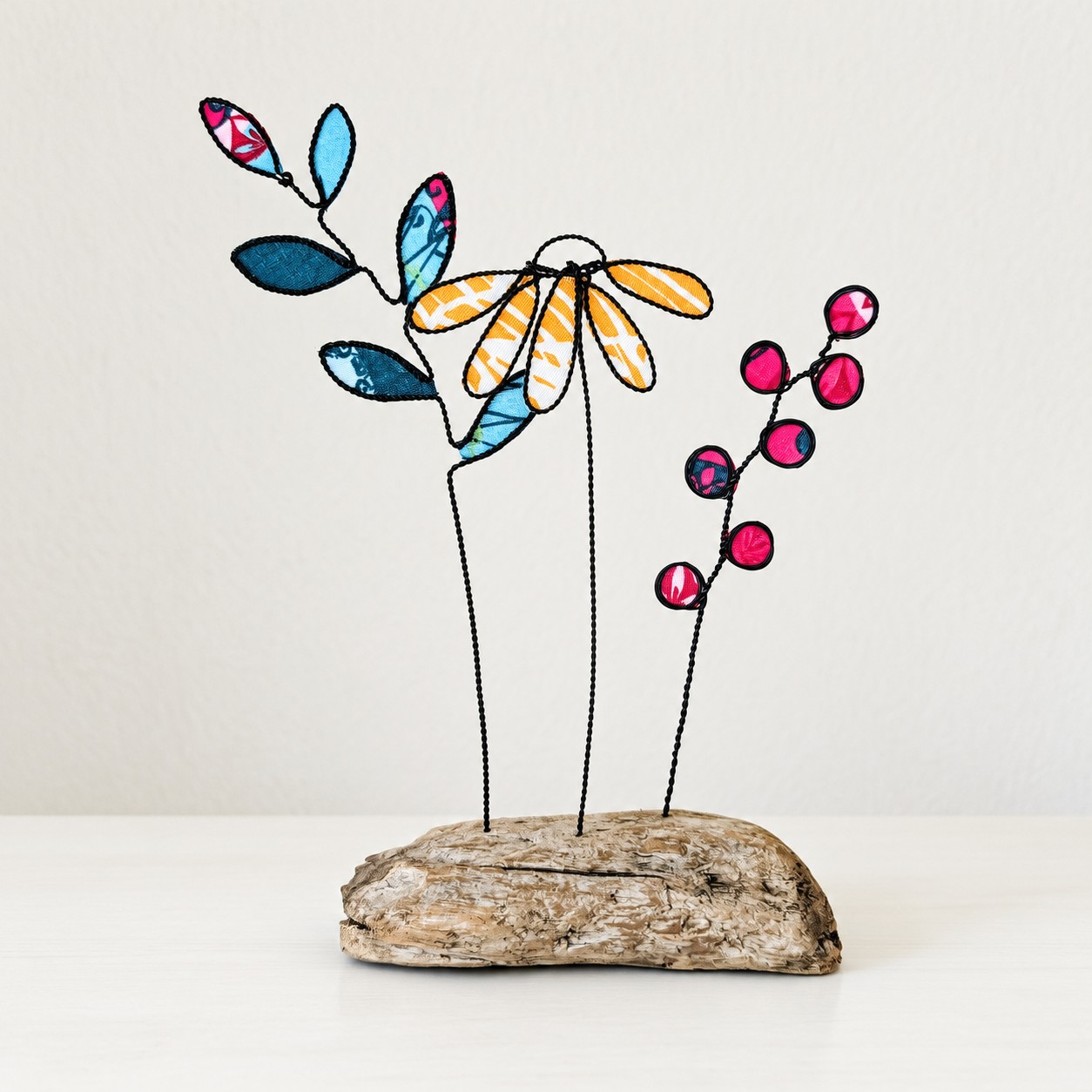 Drahtzweige mit Stoffblüten und Beeren auf Treibholz-Sockel